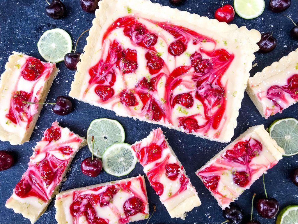 This fast and easy Cherry Limeade Tart is a perfect summer dessert recipe. A soft lime crust is filled with lime cream cheese filling and cherry pie swirls. #cherrylimeade #summerdessert #cherrydessert #tart