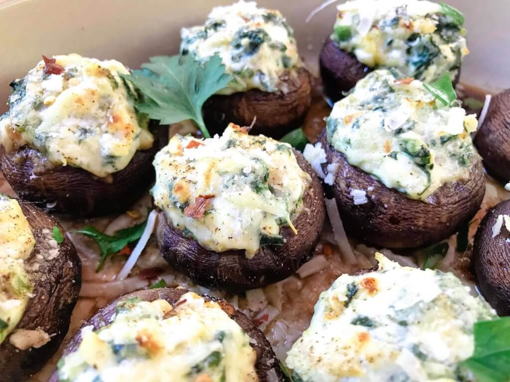 Fast and easy appetizer recipe for party entertaining finger food and game day. Gluten free, low carb keto, and vegetarian, these Spinach Artichoke Dip Stuffed Mushrooms are filled with cheese, spinach, and artichoke hearts. #stuffedmushrooms #glutenfreerecipes #spinachartichokedip