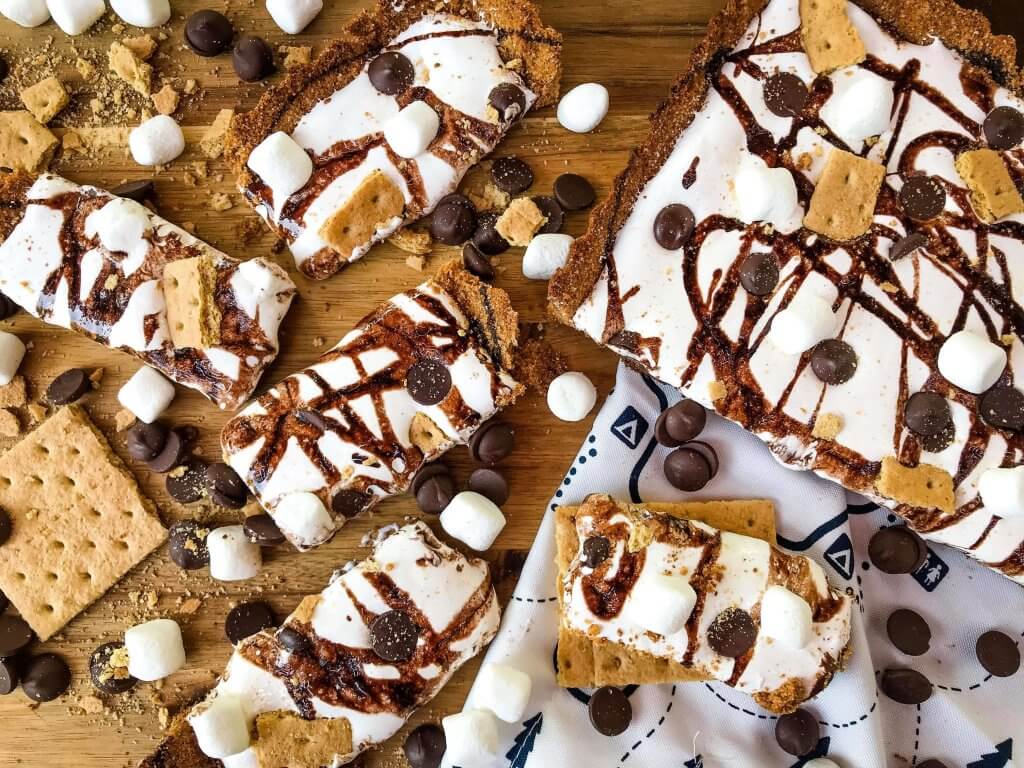 A S'mores Tart for summer dessert recipes. A graham cracker crust is filled with melted chocolate, marshmallow fluff, and s'mores ingredients. Simple and easy. #smores #tartrecipe