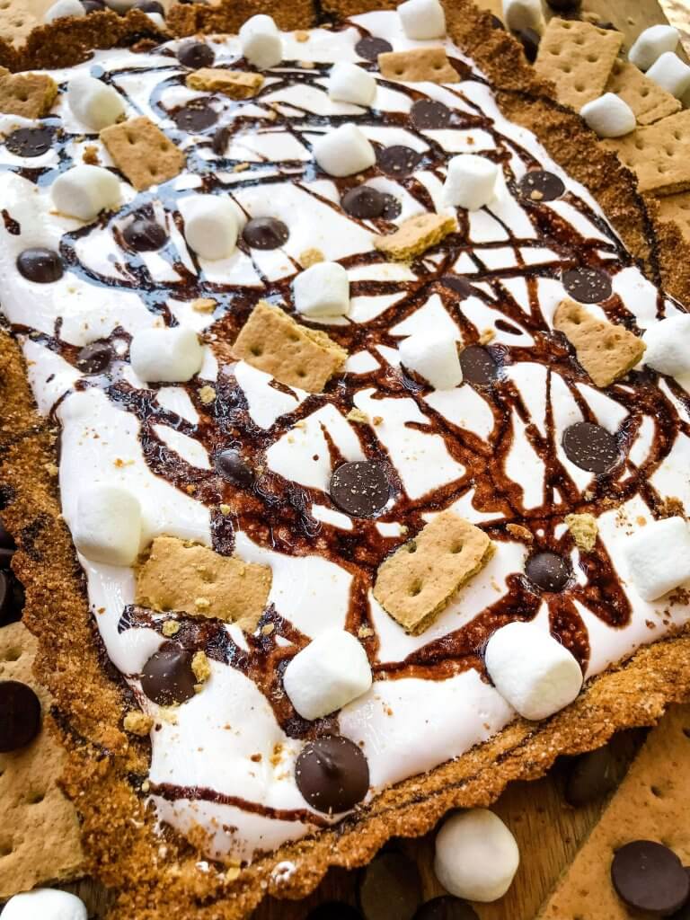 A S'mores Tart for summer dessert recipes. A graham cracker crust is filled with melted chocolate, marshmallow fluff, and s'mores ingredients. Simple and easy. #smores #tartrecipe