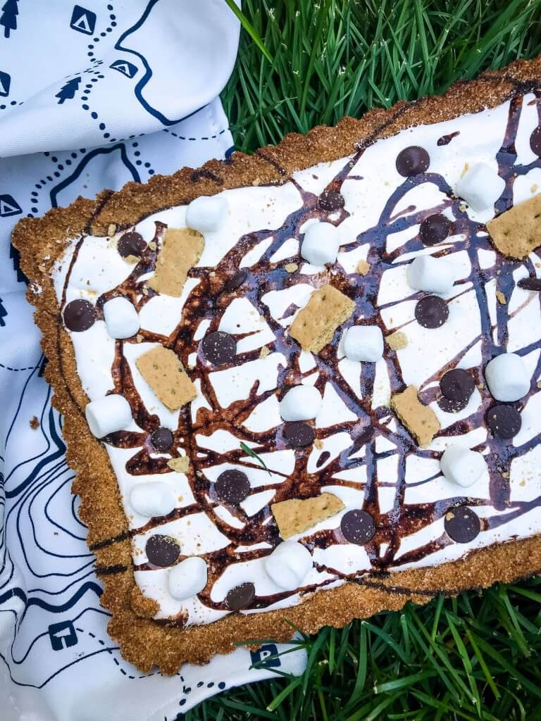 A S'mores Tart for summer dessert recipes. A graham cracker crust is filled with melted chocolate, marshmallow fluff, and s'mores ingredients. Simple and easy. #smores #tartrecipe