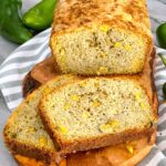 A loaf of Hatch Green Chile Cheddar Cornbread being cut into slices