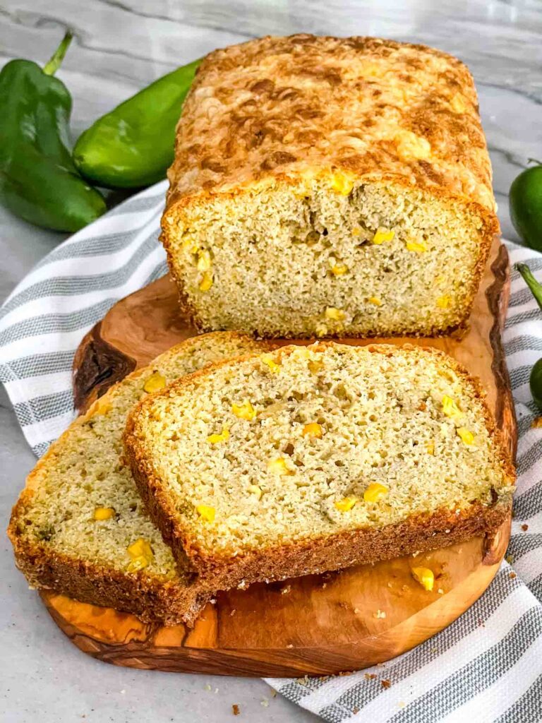 A loaf of Hatch Green Chile Cheddar Cornbread being cut into slices