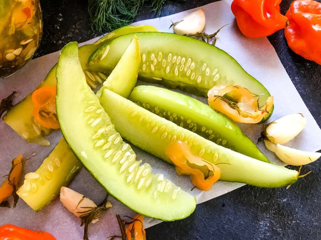 These homemade spicy pickles are easy to make! A dill pickle with a hint of garlic and a spicy pepper kick, these Homemade Habanero Garlic Pickles are vegan, vegetarian, gluten free, and dairy free. Cut the cucumbers in any shape you prefer. #homemadepickles #spicypickles