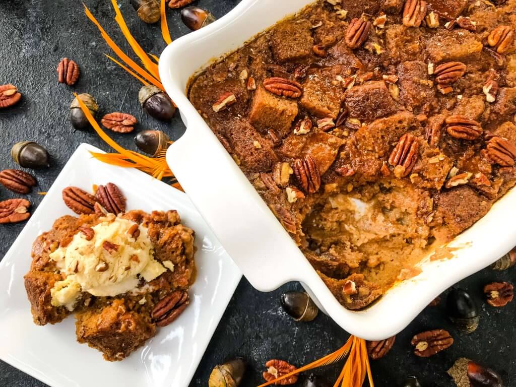 A portion of the Pumpkin Bread Pudding removed from the baking dish on a plate next to it