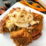 A postion of Pumpkin Bread Pudding on a white plate with vanilla ice cream on top