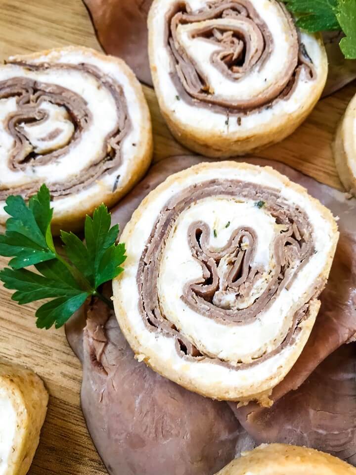 A fast and easy appetizer recipe ready in 20 minutes, Horseradish Roast Beef Pinwheels combine classic flavors in a party finger food. Roast beef is layered with a horseradish cream cheese mixture and rolled in flour tortillas. #gamedayrecipes #partyappetizers #holidayappetizers