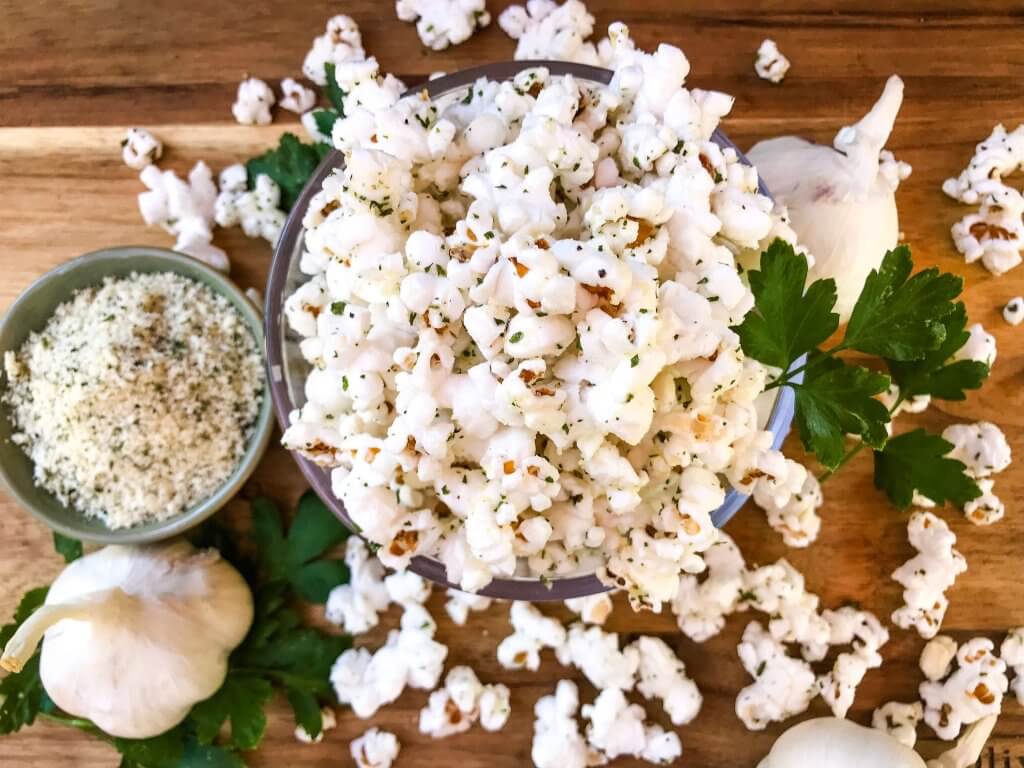 Ready in 10 minutes, Homemade Parmesan Garlic Popcorn is a fast and easy snack recipe. Parmesan cheese, garlic powder, and parsley season this healthy, gluten free, vegetarian appetizer. Great for party entertaining and game day. #homemadepopcorn #gamedayrecipes