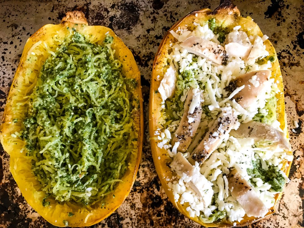 The squash halves being filled with ingredients before baking