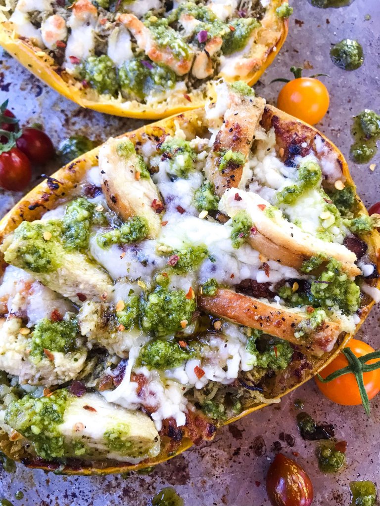 A half squash filled with chicken, pesto, and cheese