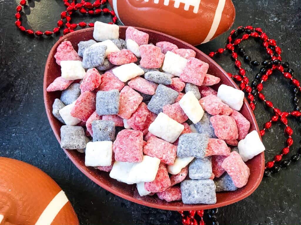 Red, white, and black muddy buddies mixed up in a bowl