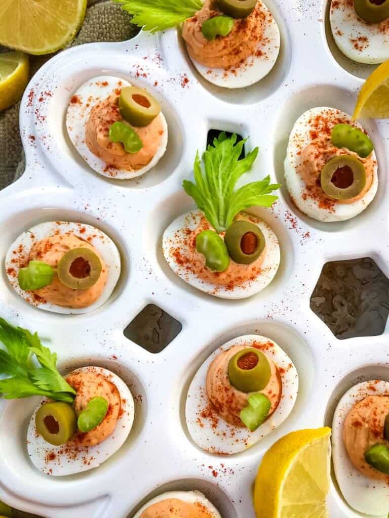 Bloody Mary Deviled Eggs recipe using the same cocktail ingredients. Tomato, celery salt, garlic, Worcestershire, and lemon in a fun game day and party appetizer finger food. #deviledeggs #bloodymary #gamedayrecipes