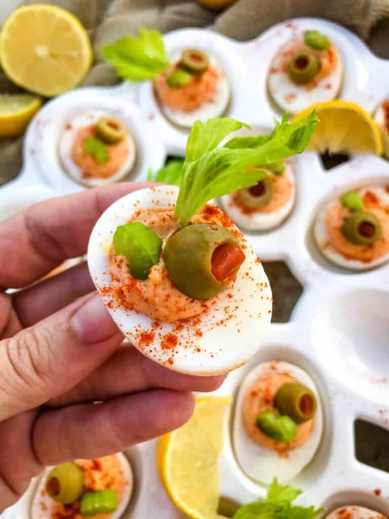 Bloody Mary Deviled Eggs recipe using the same cocktail ingredients. Tomato, celery salt, garlic, Worcestershire, and lemon in a fun game day and party appetizer finger food. #deviledeggs #bloodymary #gamedayrecipes