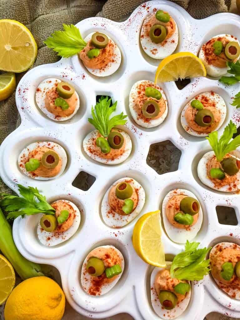 Bloody Mary Deviled Eggs recipe using the same cocktail ingredients. Tomato, celery salt, garlic, Worcestershire, and lemon in a fun game day and party appetizer finger food. #deviledeggs #bloodymary #gamedayrecipes