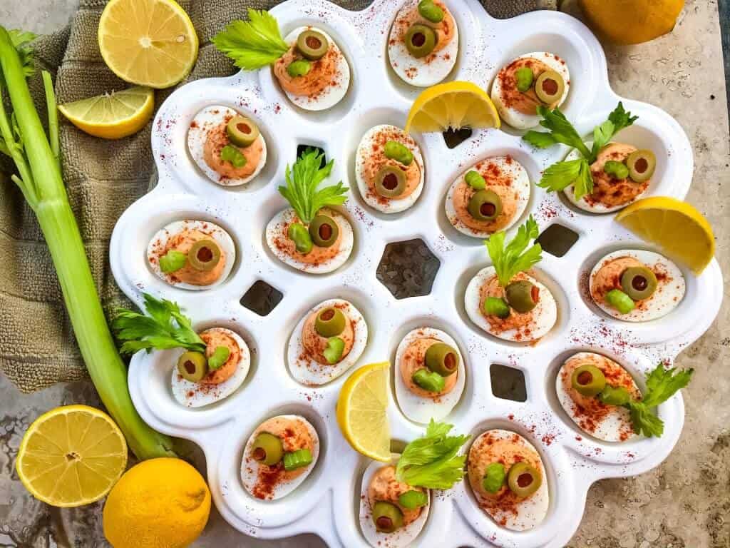 Bloody Mary Deviled Eggs recipe using the same cocktail ingredients. Tomato, celery salt, garlic, Worcestershire, and lemon in a fun game day and party appetizer finger food. #deviledeggs #bloodymary #gamedayrecipes