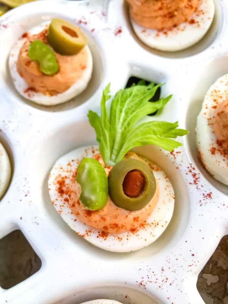 Bloody Mary Deviled Eggs recipe using the same cocktail ingredients. Tomato, celery salt, garlic, Worcestershire, and lemon in a fun game day and party appetizer finger food. #deviledeggs #bloodymary #gamedayrecipes