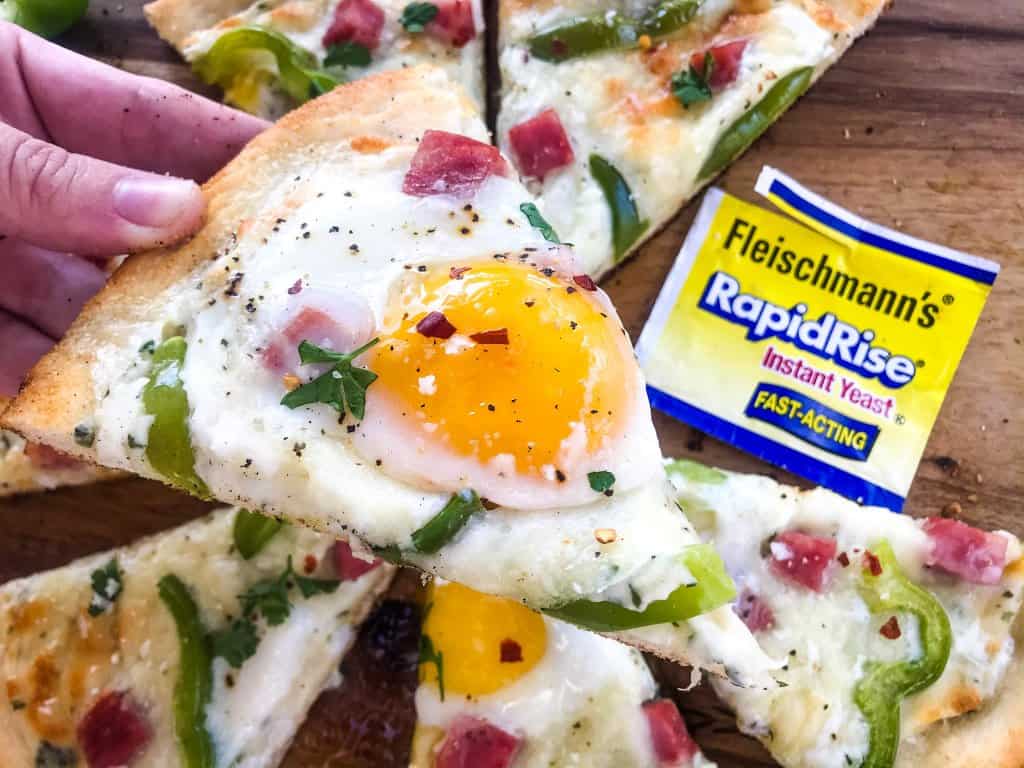 This Denver Omelet Pizza is ready in just 30 minutes using Fleischmann’s® RapidRise® Yeast, topped with a white sauce, ham, green bell peppers, and eggs. #HomemadePizzaCrust #homemadepizza