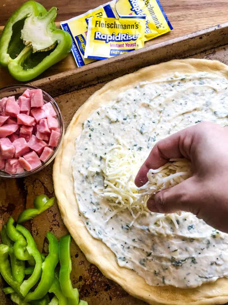 This Denver Omelet Pizza is ready in just 30 minutes using Fleischmann’s® RapidRise® Yeast, topped with a white sauce, ham, green bell peppers, and eggs. #HomemadePizzaCrust #homemadepizza