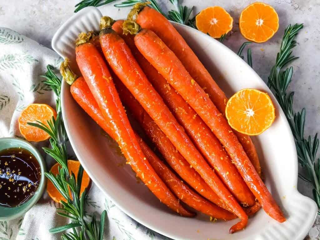 Orange Maple Glazed Carrots are a fast and simple side dish recipe ready in 20 minutes! Perfect for holiday dinners like Easter. Fresh and sweet flavors of orange and maple syrup in a simple sauce. Gluten free and vegan. #glazedcarrots #easterrecipes #sidedishrecipes