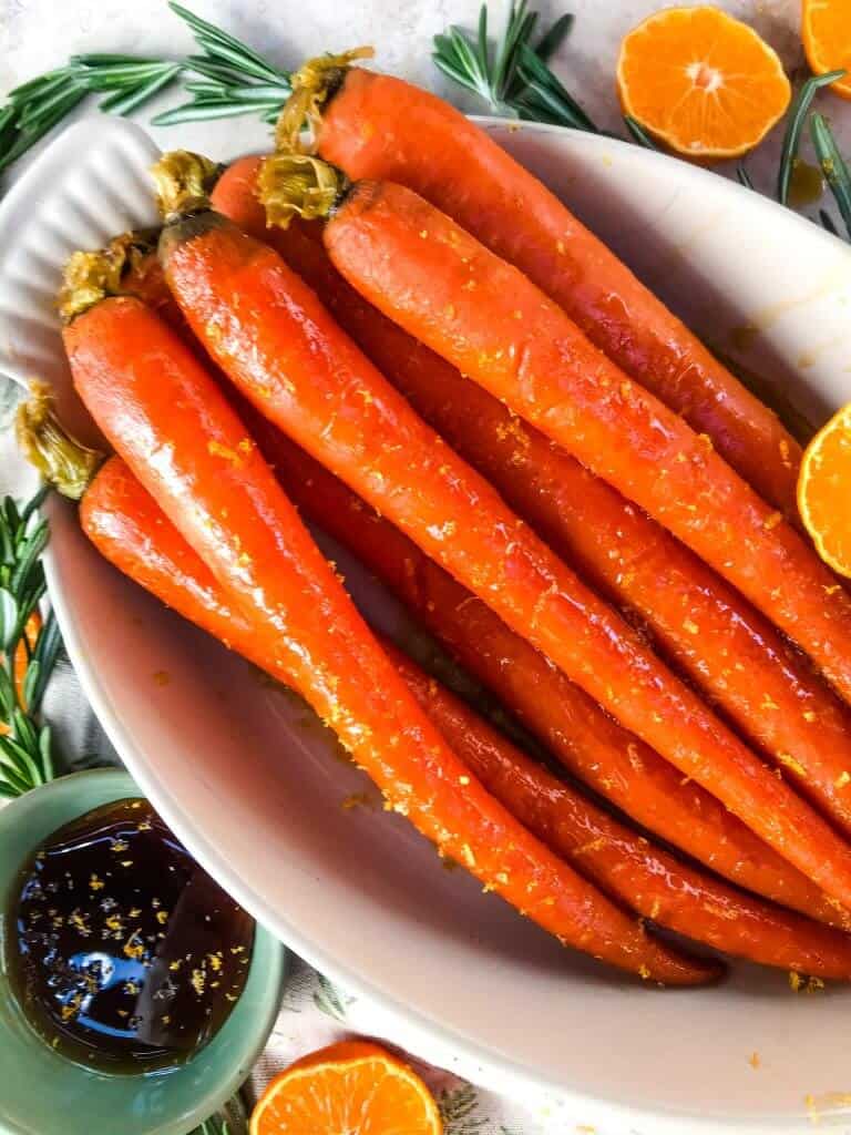 Orange Maple Glazed Carrots are a fast and simple side dish recipe ready in 20 minutes! Perfect for holiday dinners like Easter. Fresh and sweet flavors of orange and maple syrup in a simple sauce. Gluten free and vegan. #glazedcarrots #easterrecipes #sidedishrecipes