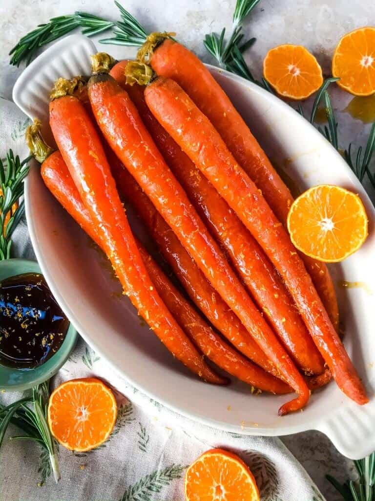Orange Maple Glazed Carrots are a fast and simple side dish recipe ready in 20 minutes! Perfect for holiday dinners like Easter. Fresh and sweet flavors of orange and maple syrup in a simple sauce. Gluten free and vegan. #glazedcarrots #easterrecipes #sidedishrecipes