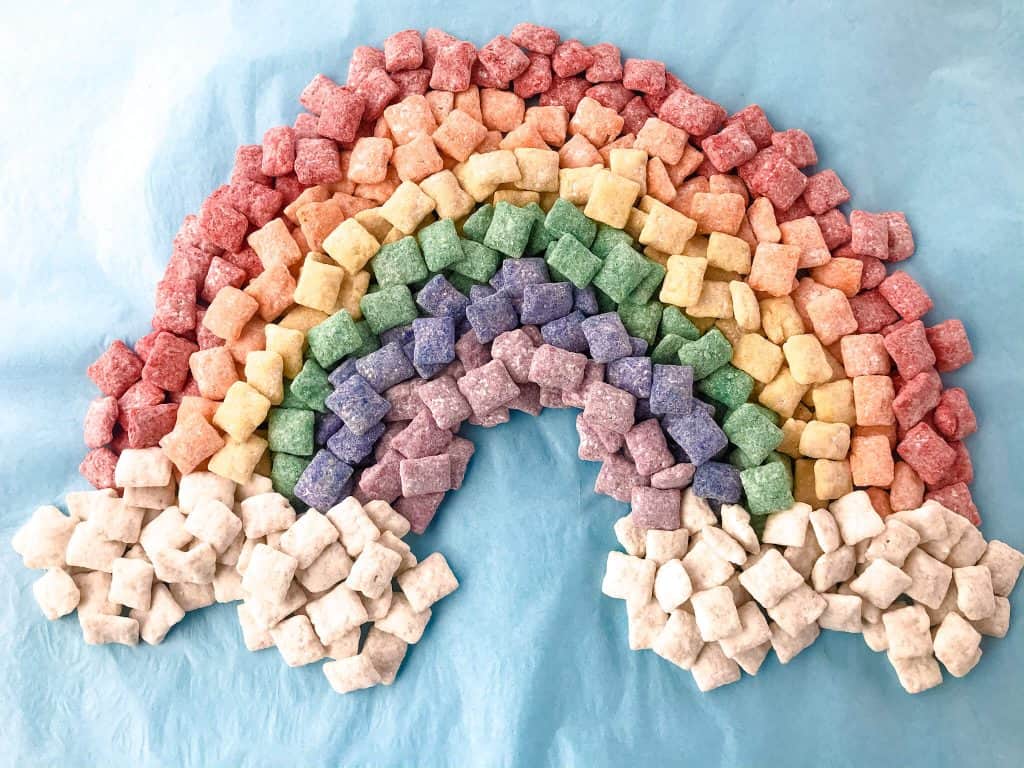 Rainbow Puppy Chow recipe is a colorful dessert perfect for a unicorn rainbow party, St Patrick's Day, or Pride month. Gluten free and vegetarian. #rainbowpuppychowrecipe #puppychow #rainbow #unicorn #pride