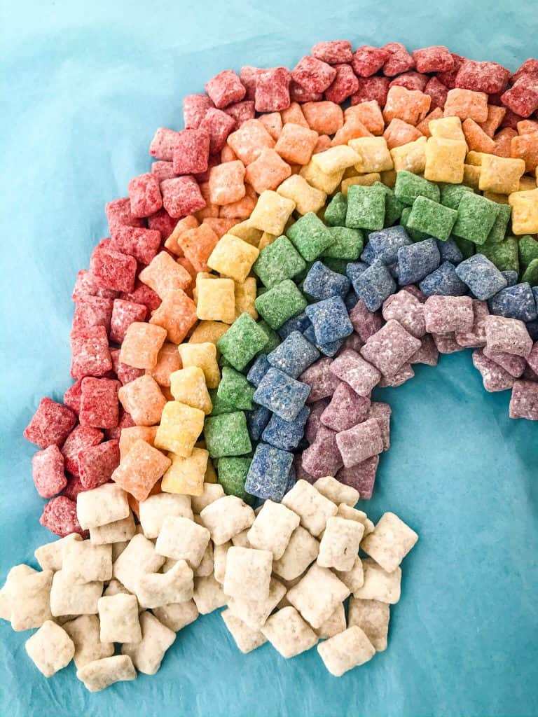 Rainbow Puppy Chow recipe is a colorful dessert perfect for a unicorn rainbow party, St Patrick's Day, or Pride month. Gluten free and vegetarian. #rainbowpuppychowrecipe #puppychow #rainbow #unicorn #pride