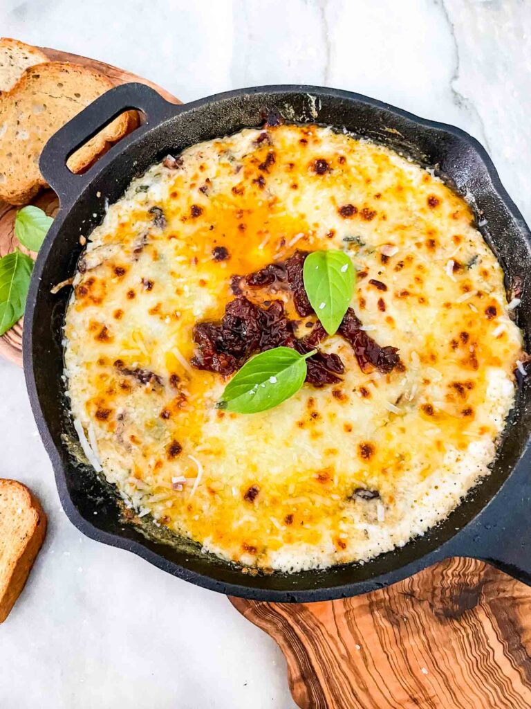 A cast iron skillet full of Tuscan Cheese Dip