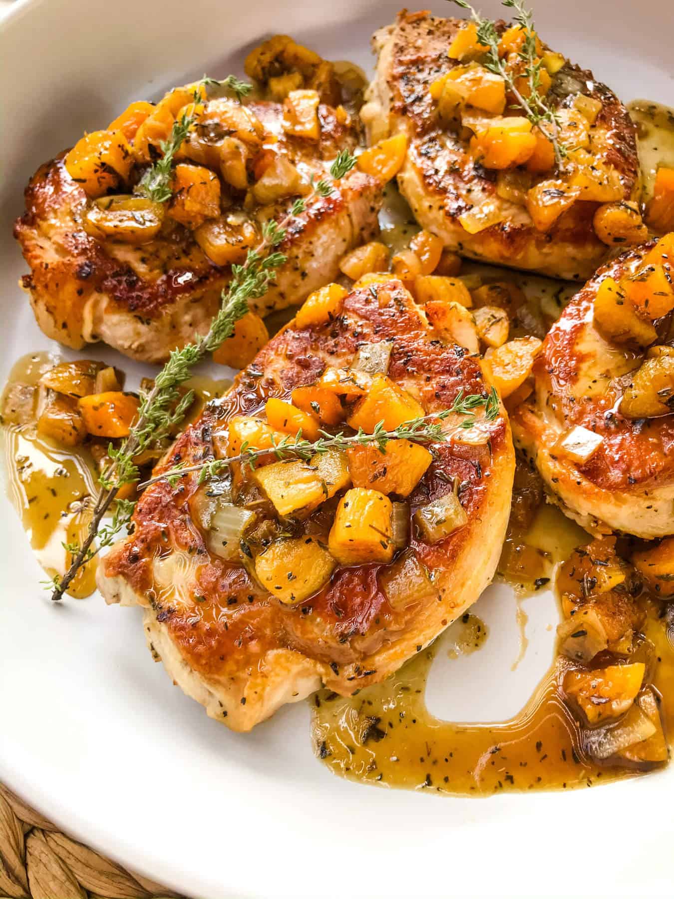 Bourbon Apricot Pork Chops in a large dish with dried thyme garnish