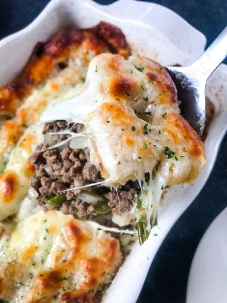 Philly Cheesesteak Tater Tot Casserole is a cheesy beef casserole recipe mixed with onion, green bell pepper, provolone cheese, and potato tater tots. An easy dinner idea for busy nights for the family. #beefcasserole #cheesesteak #hamburgercasserole