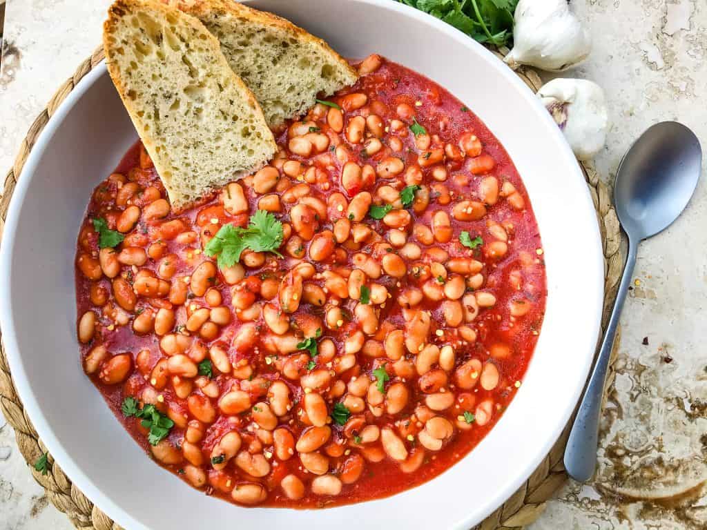 Arrabbiata Beans (Spicy Italian Beans) are based on the classic Italian pasta recipe. A spicy tomato sauce filled with garlic and crushed red pepper flakes with white beans. Vegan and gluten free pantry recipe. #beanrecipes #spicyItalian #Italianbeans