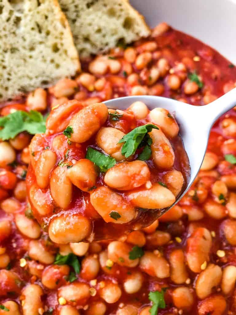 Arrabbiata Beans (Spicy Italian Beans) are based on the classic Italian pasta recipe. A spicy tomato sauce filled with garlic and crushed red pepper flakes with white beans. Vegan and gluten free pantry recipe. #beanrecipes #spicyItalian #Italianbeans