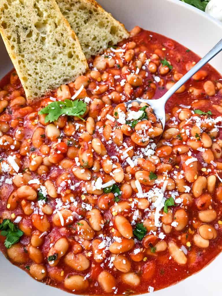 Arrabbiata Beans (Spicy Italian Beans) are based on the classic Italian pasta recipe. A spicy tomato sauce filled with garlic and crushed red pepper flakes with white beans. Vegan and gluten free pantry recipe. #beanrecipes #spicyItalian #Italianbeans