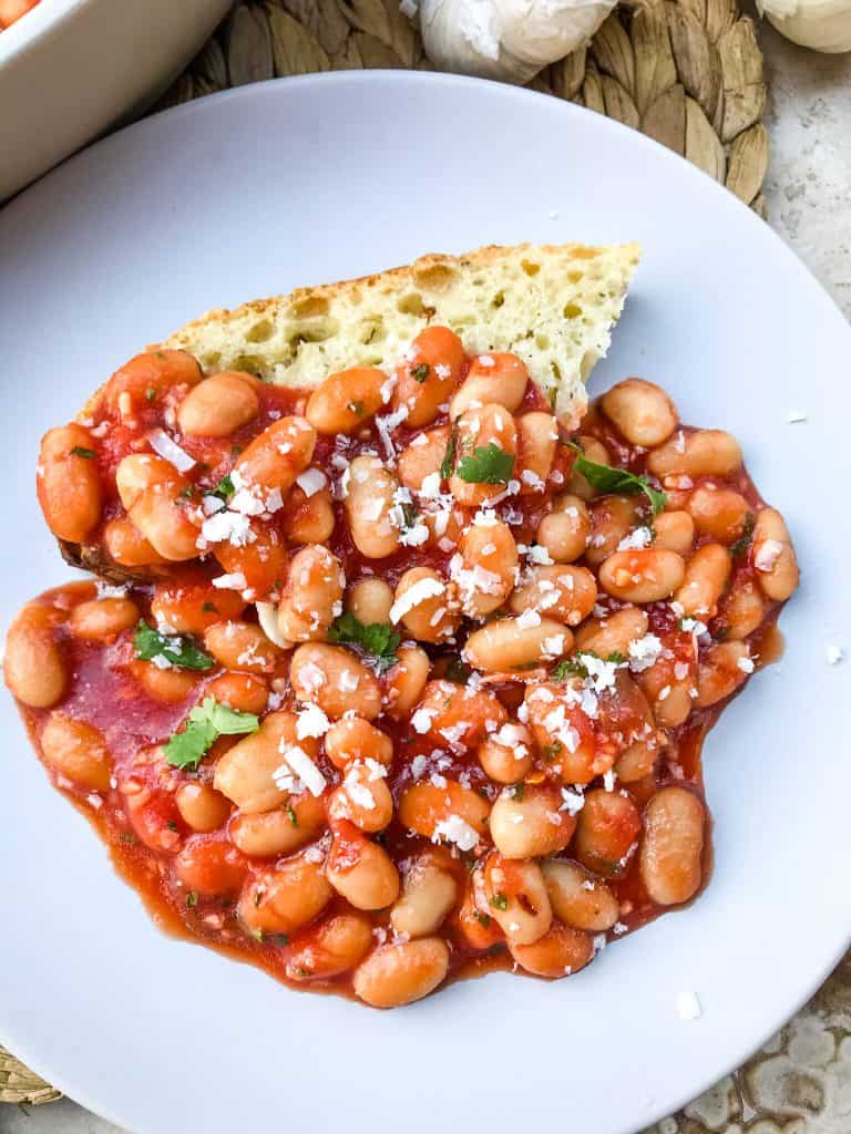 Arrabbiata Beans (Spicy Italian Beans) are based on the classic Italian pasta recipe. A spicy tomato sauce filled with garlic and crushed red pepper flakes with white beans. Vegan and gluten free pantry recipe. #beanrecipes #spicyItalian #Italianbeans