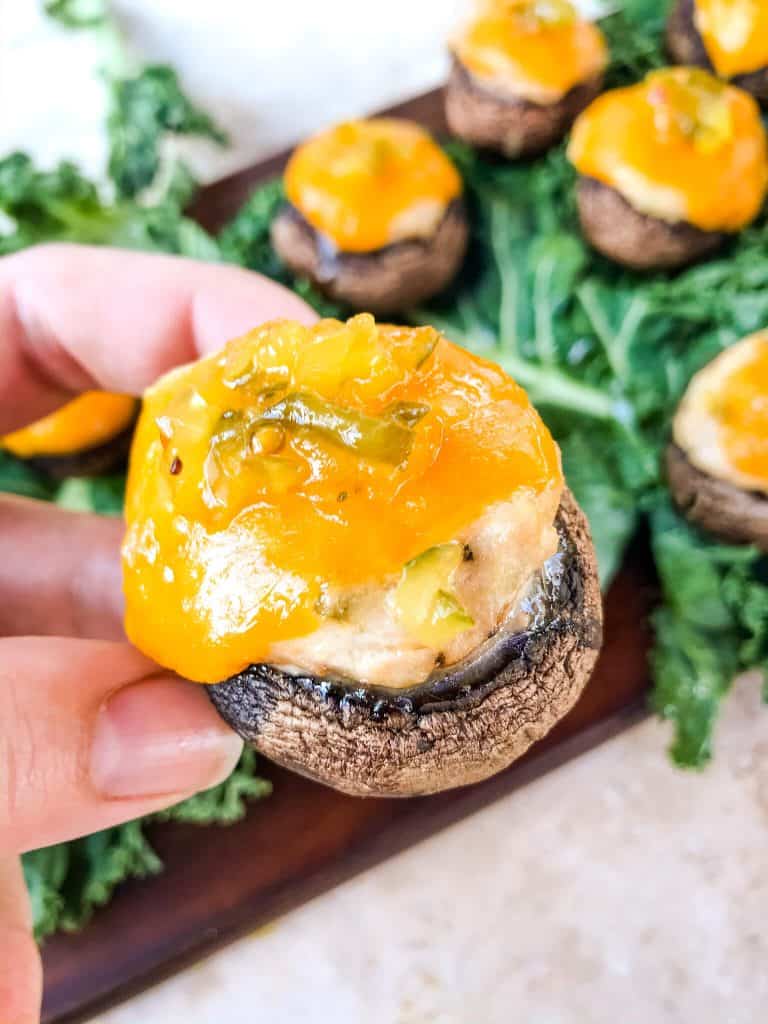 A hand holding a stuffed mushroom