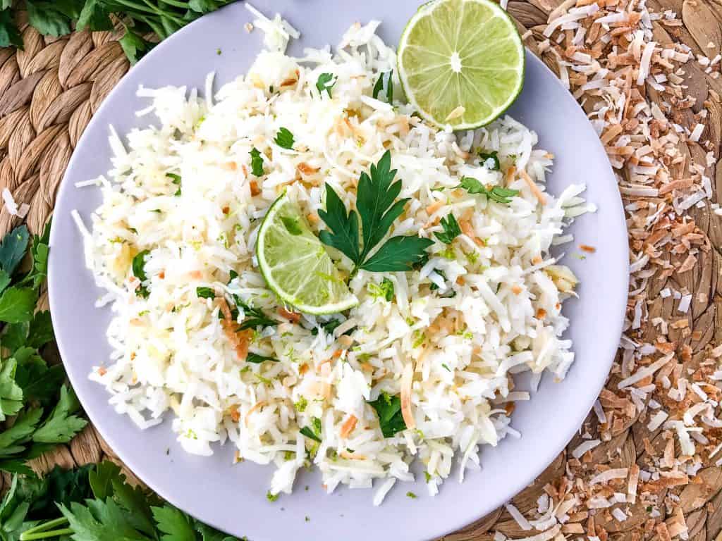 Coconut Lime Rice is a tropical side dish recipe made with coconut milk, toasted coconut flakes, and fresh lime. Vegan, vegetarian, and gluten free. Also can be made in a rice cooker or Instant Pot. #coconutrice #coconutlime #ricerecipes