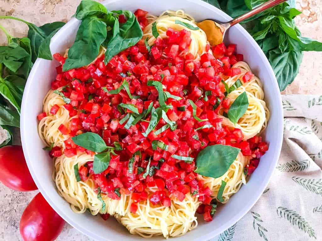 Copycat Olive Garden Capellini Pomodoro is a fresh, easy tomato basil pasta. Fresh tomatoes and basil on angel hair pasta to replicate the vegan Italian pasta restaurant recipes. #olivegardenrecipes #copycat #tomatopasta #tomatobasil