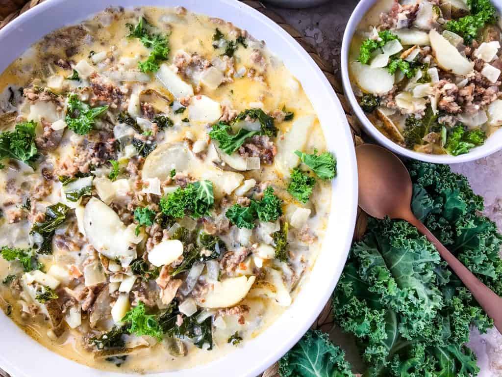 Copycat Olive Garden Zuppa Toscana in white bowls surrounded by kale