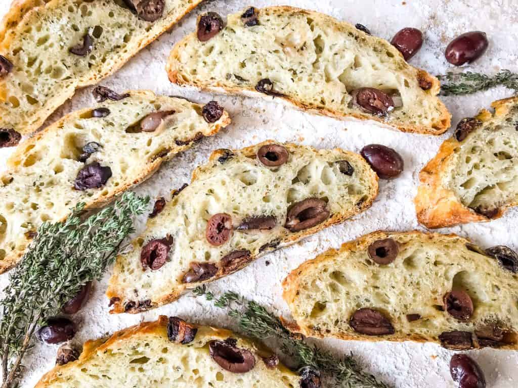 Slices of the bread with olives and thyme around them