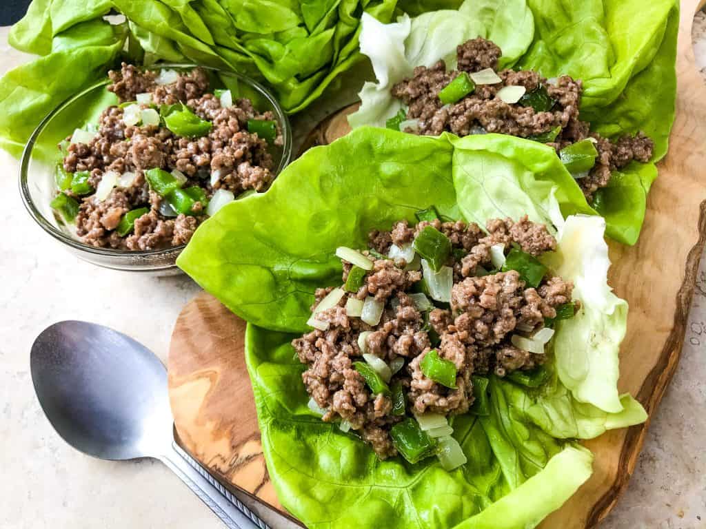 Philly Cheesesteak Lettuce Wraps are ready in less than 30 minutes! A healthy low carb, keto, gluten free recipe. Ground beef is mixed with bell pepper, onion, and provolone cheese for a simple beef lettuce cup. #phillycheesesteak #lettucewrap #groundbeef #healthyrecipe