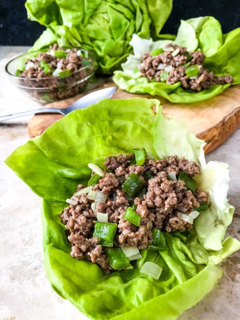 Philly Cheesesteak Lettuce Wraps are ready in less than 30 minutes! A healthy low carb, keto, gluten free recipe. Ground beef is mixed with bell pepper, onion, and provolone cheese for a simple beef lettuce cup. #phillycheesesteak #lettucewrap #groundbeef #healthyrecipe