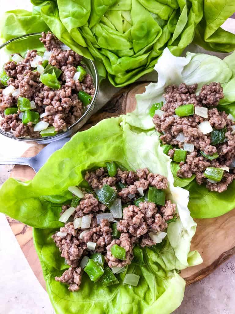 Philly Cheesesteak Lettuce Wraps are ready in less than 30 minutes! A healthy low carb, keto, gluten free recipe. Ground beef is mixed with bell pepper, onion, and provolone cheese for a simple beef lettuce cup. #phillycheesesteak #lettucewrap #groundbeef #healthyrecipe