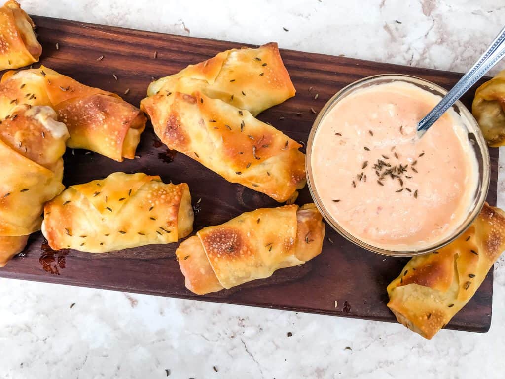 Baked Reuben Egg Rolls on a wood cutting board