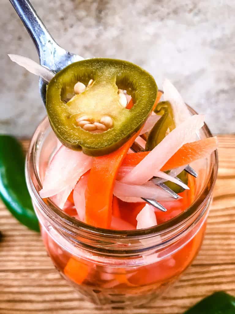 Homemade Escabeche (Mexican Pickled Vegetables) is a quick pickle recipe made with jalapeno peppers, carrot, and red onion. A gluten free and vegan refrigerator pickle that makes a great condiment. #escabeche #mexicanpickles #quickpickle #refrigeratorpickle