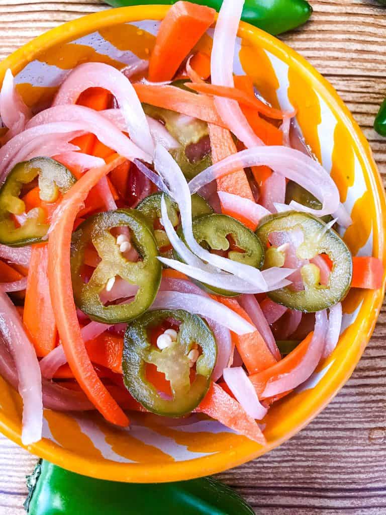 Homemade Escabeche (Mexican Pickled Vegetables) is a quick pickle recipe made with jalapeno peppers, carrot, and red onion. A gluten free and vegan refrigerator pickle that makes a great condiment. #escabeche #mexicanpickles #quickpickle #refrigeratorpickle