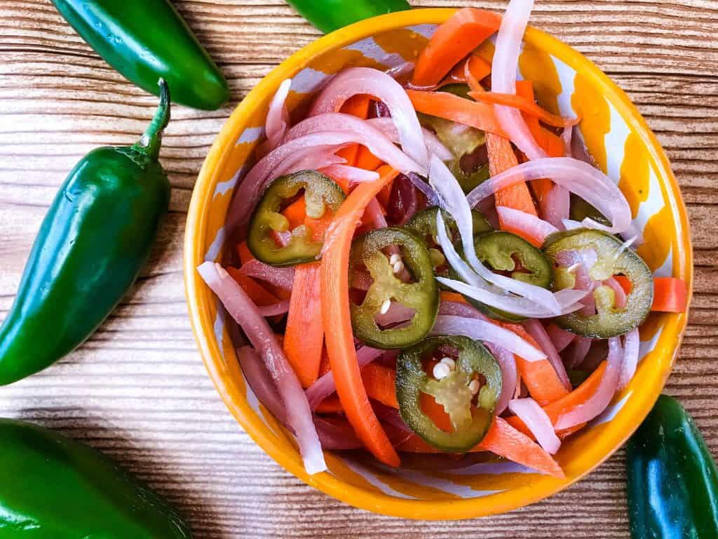 Homemade Escabeche (Mexican Pickled Vegetables) is a quick pickle recipe made with jalapeno peppers, carrot, and red onion. A gluten free and vegan refrigerator pickle that makes a great condiment. #escabeche #mexicanpickles #quickpickle #refrigeratorpickle