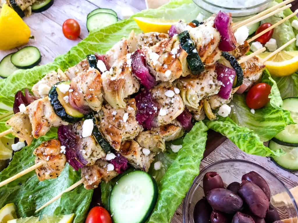 Fresh and Light Grilled Greek Chicken Skewers are a quick chicken grilling recipe for the BBQ! Chicken marinated in oil, oregano, and lemon on a kebab with onion, artichoke, and fresh Greek ingredients. Fast chicken kabob on the grill. #grilledchicken #chickenkabobs #greekchicken