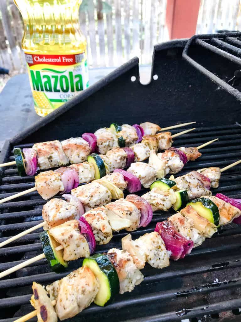 Fresh and Light Grilled Greek Chicken Skewers are a quick chicken grilling recipe for the BBQ! Chicken marinated in oil, oregano, and lemon on a kebab with onion, artichoke, and fresh Greek ingredients. Fast chicken kabob on the grill. #grilledchicken #chickenkabobs #greekchicken