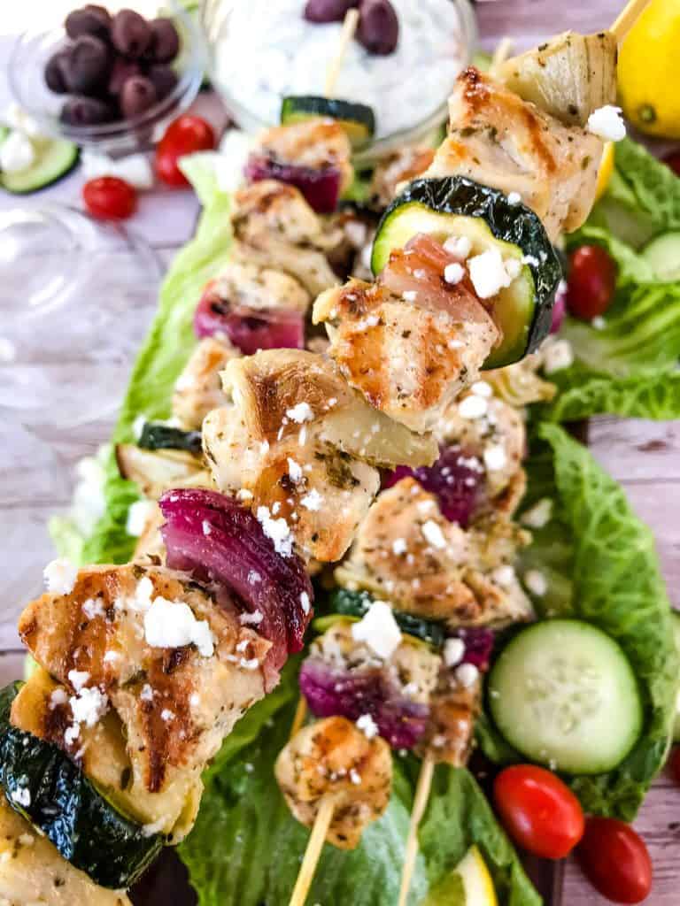 Fresh and Light Grilled Greek Chicken Skewers are a quick chicken grilling recipe for the BBQ! Chicken marinated in oil, oregano, and lemon on a kebab with onion, artichoke, and fresh Greek ingredients. Fast chicken kabob on the grill. #grilledchicken #chickenkabobs #greekchicken