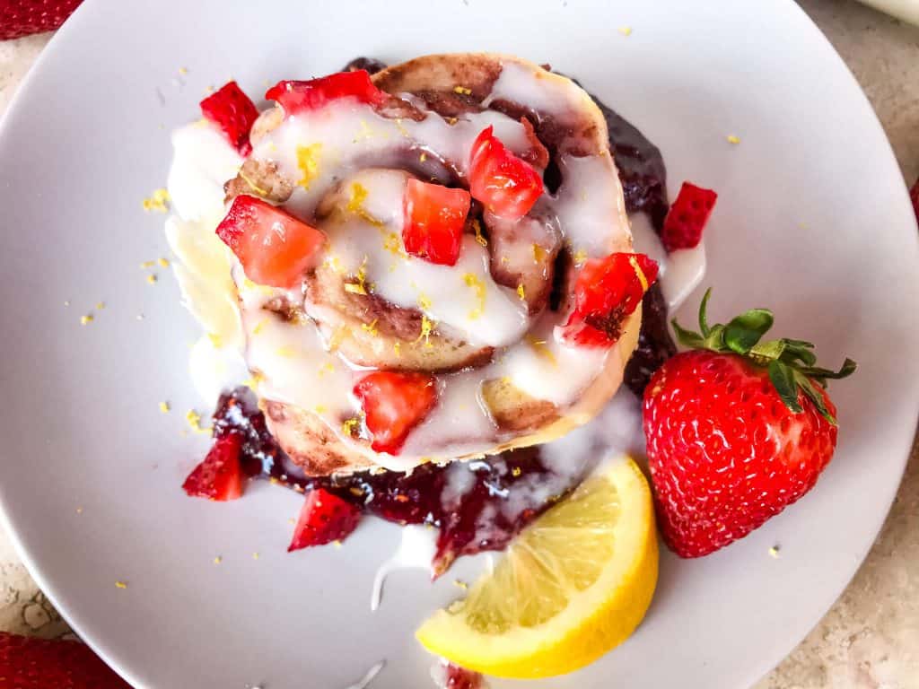 Homemade Strawberry Lemon Cinnamon Rolls with lemon icing glaze. Fresh strawberries and strawberry jam with cinnamon in a homemade dough. Bright spring and summer flavors for home breakfast and brunch baking recipes. #cinnamonrolls #strawberrylemon #bakingrecipes